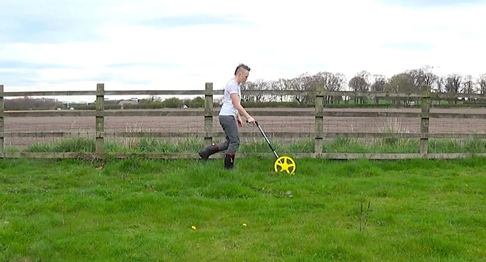 Garde Ninja surveying a garden design with a trundle wheel